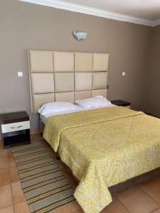 a bedroom with a large bed with a yellow bedspread at Vacation Home close to the beach in Bilene in Vila Praia Do Bilene