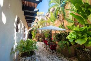 um pátio exterior com mesas, cadeiras e plantas em El Beaterio Casa Museo em Santo Domingo