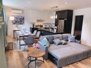 a living room with a couch and a kitchen at Free Parking - Best Travel by Zen Living in Longueuil
