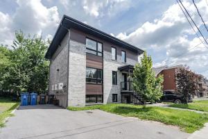 a brick house with a black roof at Free Parking - Best Travel by Zen Living in Longueuil