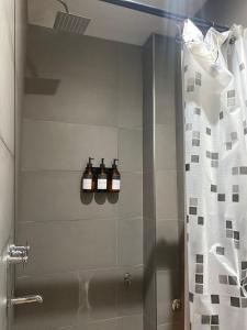 a bathroom with a shower with three bottles on the wall at Departamento Campana Centro in Campana