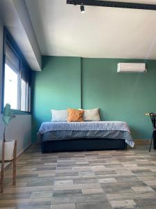 a bedroom with a bed with a blue wall at Departamento Campana Centro in Campana