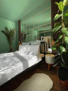 a bedroom with a white bed and a plant at Green Serenity in Bucharest