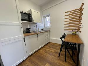 a kitchen with white cabinets and a wooden table at Green Serenity in Bucharest