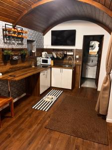 a kitchen with a table and a tv on the wall at B-HAUSE zárt parkolóval és jacuzzival in Debrecen