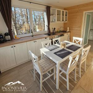 a kitchen with a white table and chairs in it at Pagony Villa in Galyatető