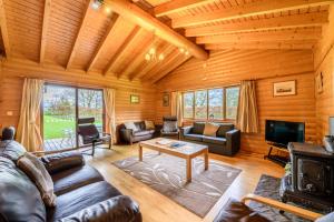 a living room with leather furniture in a log cabin at Pinecroft Lodges in Ingleton 