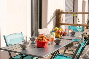 a table with a basket of fruit on a balcony at Villa Paulina, cœur village, à 5 min de la plage in Portiragnes