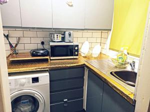a kitchen with a washing machine and a sink at Affordable Private Space in Leeds