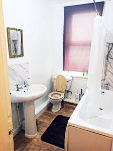a bathroom with a toilet and a sink and a tub at Affordable Private Space in Leeds