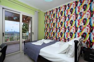 a bedroom with a bed with a colorful wall at Cozy family home in Katouna in Katouna
