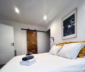 une chambre avec un lit blanc avec des serviettes dessus dans l'établissement L'OlivierBlanc, à Vendémian