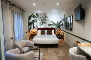 a bedroom with a bed and two chairs at Villa Pruly Hotel Cannes Centre in Cannes