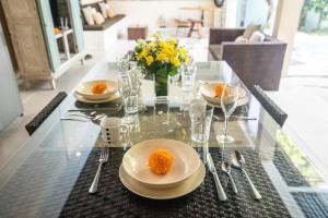 a dining table with plates and forks and spoons at Enigma Bali Villas Complex Canggu in Canggu