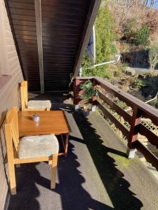 einen Holztisch und zwei Stühle auf einer Veranda in der Unterkunft Haus Waldesruh in Medebach