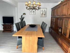 a dining room with a wooden table and chairs at Haus Waldesruh in Medebach