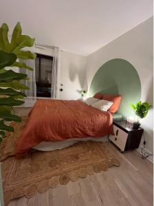 1 dormitorio con 1 cama grande con manta naranja en Parisian cocoon- Luxembourg garden- Independant en París
