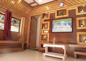 a room with a table and a tv on a wall at Falling Water Resort By Travent Mug in Sakleshpur