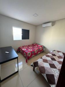 Zimmer mit einem Bett, einem Tisch und einem TV in der Unterkunft Aluguel por temporada em Piranhas in Piranhas