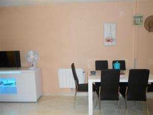 uma sala de jantar com uma mesa e cadeiras pretas em Appartement Saint-Hilaire-de-Riez, 3 pièces, 6 personnes - FR-1-324A-21 em Saint-Hilaire-de-Riez