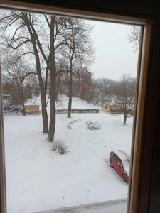 um carro vermelho estacionado num quintal coberto de neve em Městské kulturní centrum ve Fulneku em Nový Jičín