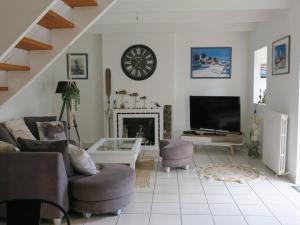 a living room with a fireplace and a clock on the wall at Maison de charme 3* avec WIFI, jardin clos, véranda, à 350m du port à Perros-Guirec - FR-1-368-254 in Perros-Guirec