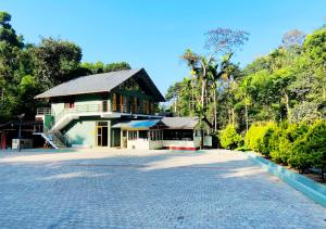 a building with a large driveway in front of it at Falling Water Resort By Travent Mug in Sakleshpur