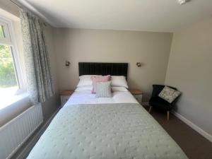 1 dormitorio con 1 cama blanca grande y 1 silla en Anchor Inn en Taunton