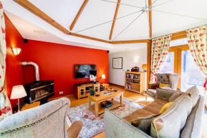 a living room with a red wall at Heads Nook Hall Cottage in Carlisle
