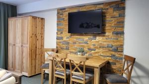 uma sala de jantar com uma mesa de madeira contra uma parede de tijolos em Apartmány Nízke Tatry - Krpáčovo em Dolná Lehota