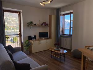 a living room with a couch and a tv at Lakeside Apartment in Gravedona