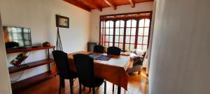 a dining room table with black chairs in a room at HOSPEDAJE EL GRINGO - CASA ALOJAMIENTO COMPLETO in Río Grande