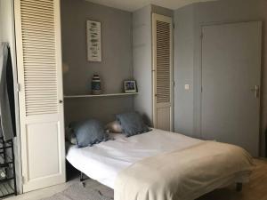 - une chambre avec un lit blanc et 2 oreillers bleus dans l'établissement Residence La Seigneurie, à Ouistreham