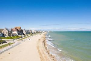 - une vue sur la plage avec des maisons et l'océan dans l'établissement Residence La Seigneurie, à Ouistreham