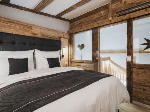 ein Schlafzimmer mit einem großen Bett und einem großen Fenster in der Unterkunft VAYA Seefeld in Seefeld in Tirol