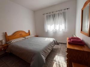 a bedroom with a bed and a dresser and a window at Apartamento La Ermita in Chulilla