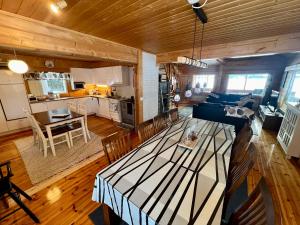 ein Wohnzimmer und eine Küche mit einem Tisch und einer Couch in der Unterkunft Villa Kuusiranta in Ähtäri + 6 Fotos