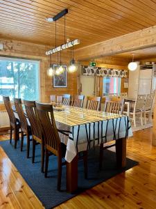 ein Esszimmer mit einem großen Holztisch und Stühlen in der Unterkunft Villa Kuusiranta in Ähtäri