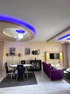 - un salon avec une table et un canapé violet dans l'établissement Luxury apartment Madinaty families Only, à Madinaty