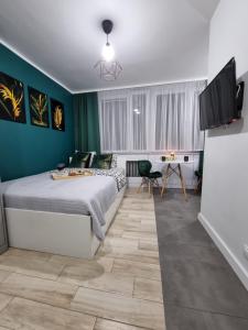 ein Schlafzimmer mit einem großen Bett und einem Schreibtisch in der Unterkunft 13A Kawalerka Szmaragdowa in Częstochowa