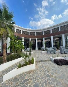 un edificio con cortile con tavoli e palme di Ekor Elegance Hotel a Famagusta
