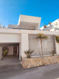 une maison blanche avec un palmier en face dans l'établissement Luxury Bella House Quesada, à Rojales
