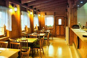 a dining room with tables and chairs in a restaurant at Penzion Kameňák in Horní Planá