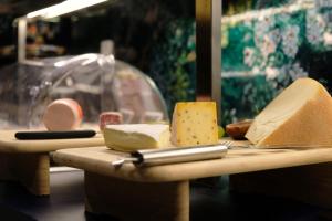 a table with different types of cheese and a knife at Hotel Eastside (free parking garage) in St. Gallen