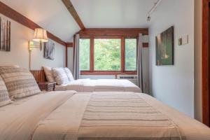 two beds in a room with a window at Cranmore Mountain Lodge Bed & Breakfast in North Conway