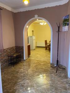 an archway in a living room with a table and a refrigerator at Будинок для відпочинку Патріція in Berehove