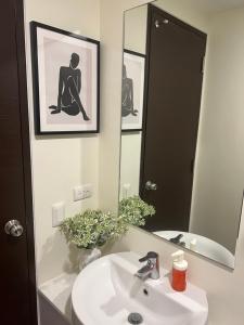 La salle de bains est pourvue d'un lavabo et d'un miroir. dans l'établissement Condotel in Abreeza Ayala Mall, à Davao