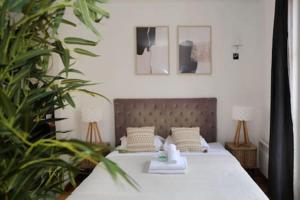 a bedroom with a bed with white sheets and plants at 303- Relaxez vous dans un studio de charme Paris 5 in Paris