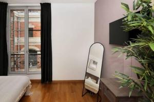 a bedroom with a bed and a mirror and a window at 303- Relaxez vous dans un studio de charme Paris 5 in Paris