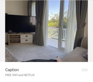 a person laying on a couch in a living room with a television at Orchard View Caravan in Boston